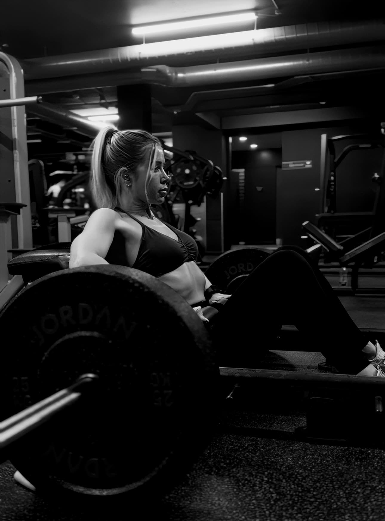 Woman performing a barbell hip thrust during a strength training session